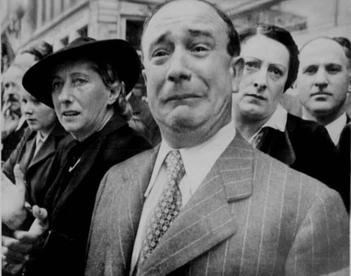 Un ciudadano francés llora mientras los soldados alemanes marchan en París durante la ocupación francesa