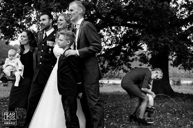 fotos de bodas novios posando y al fondo un niño orinando