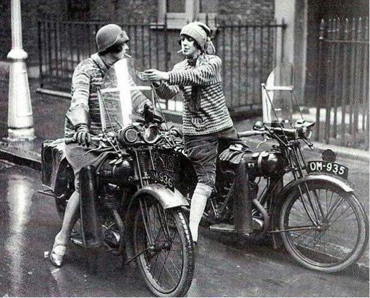 Imágenes Históricas Dos mujeres británicas, montadas en sus motocicletas, deteniéndose para encender sus cigarrillos 1930