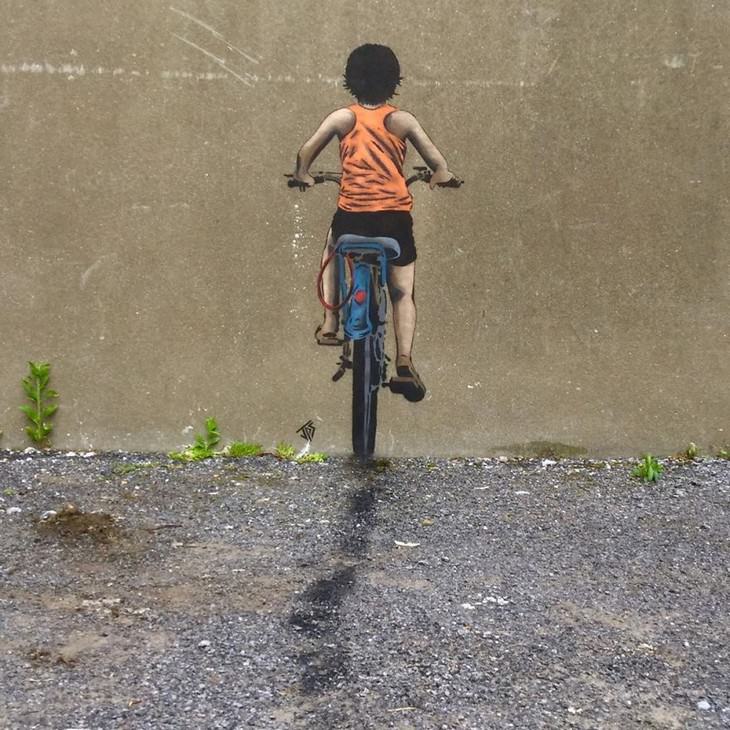 Arte callejero de Jamie Paul Scanlon niño en bicicleta