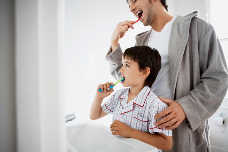 Experts Reveal: How Often You Should Really Shower, father and son brushing teeth