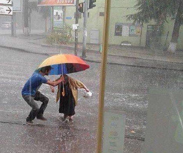 fotos lindas joven que ayuda a señora con la lluvia