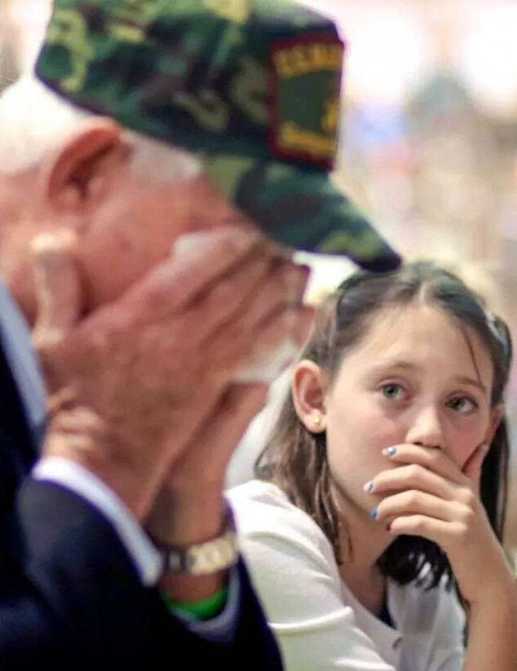  Una niña junto a su abuelo en el día de los Veteranos de Guerra