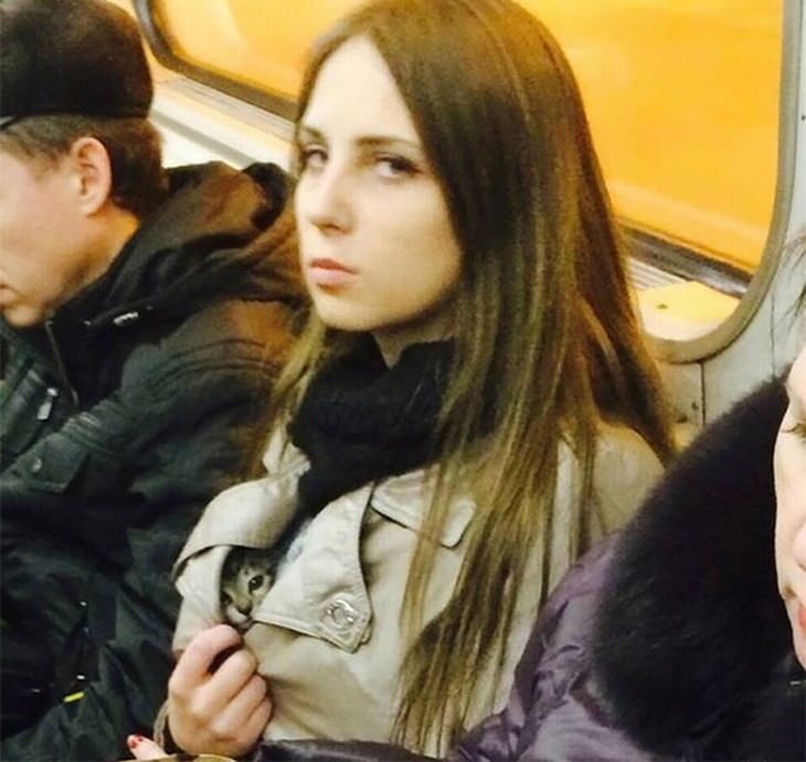 Imágenes divertidas en el metro mujer con gato bajo su chaqueta