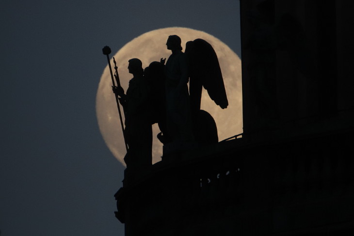 La superluna en el fondo de estatuas montadas en una catedral