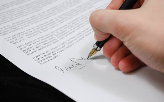 una persona firmando un documento