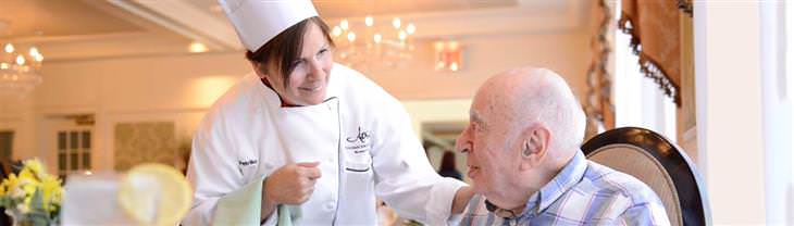 5 Excepcionales Diseños De Hogares De Ancianos Del Mundo Atria West 86, Nueva York, EE. UU chef ofrece comida a adulto mayor