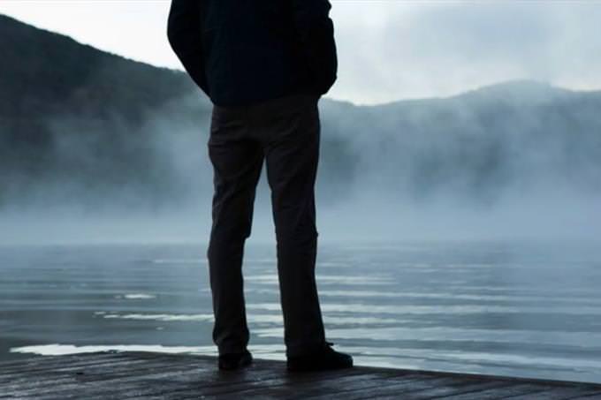 man standing at the edge of a lake