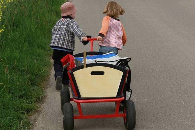 dos niños jalando un carrito