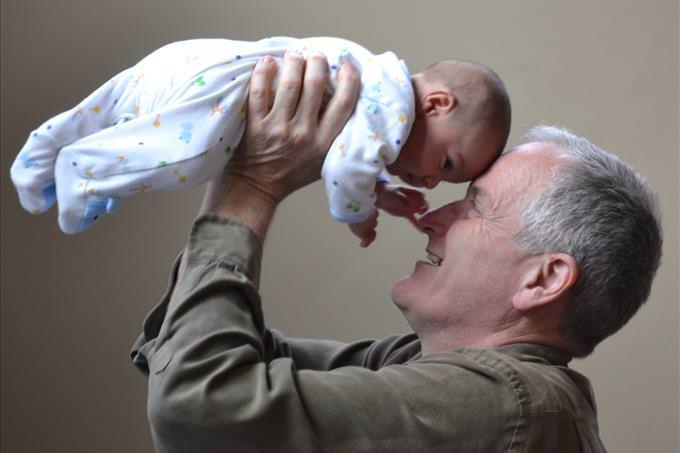 elderly man holding baby