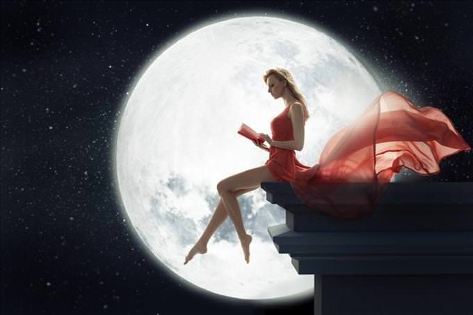 lady in red dress sitting in front of full moon