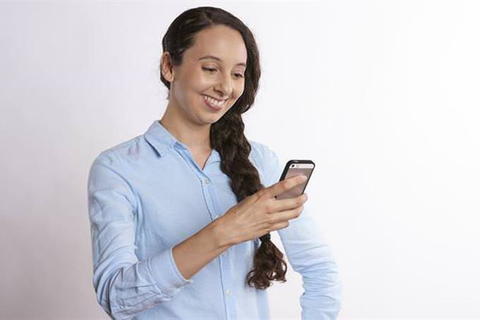 test: mujer viendo un celular y sonriendo