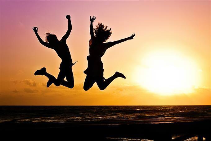 women jumping on the beach
