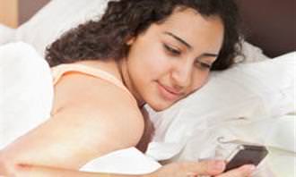 girl using smartphone in bed