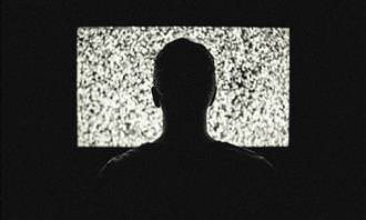 man watching static on TV