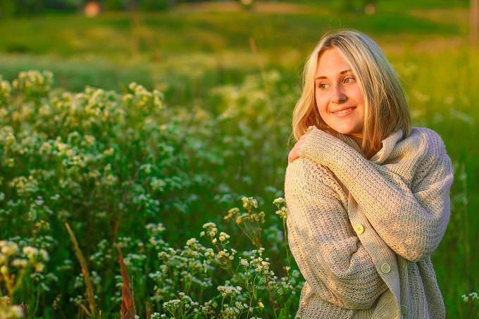 Test de Personalidad: Una mujer sonriente en un campo verde.
