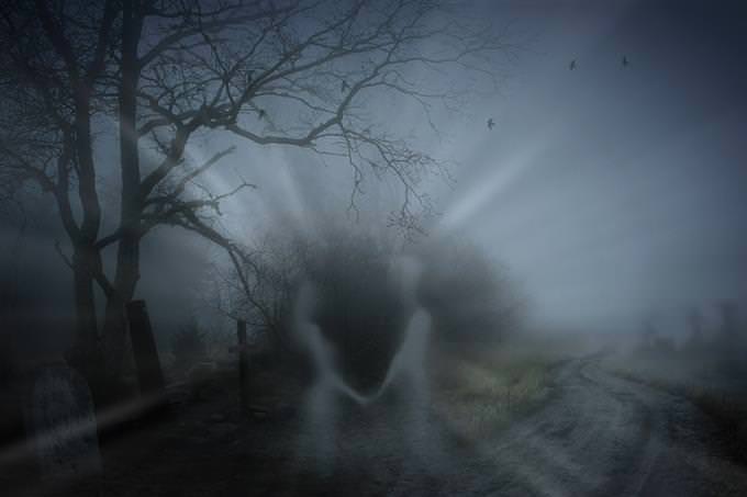 Figuras de fantasmas en el contexto de un cementerio en la noche