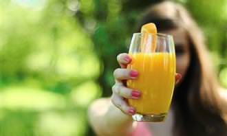 woman holding orange juice