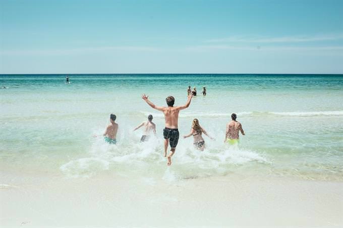 Group of people jumping into the ocean