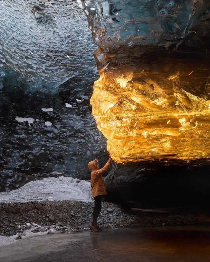 21. Solo una parte de esta cueva de hielo en Islandia está iluminada por los rayos del sol, lo que hace que parezca un enorme cristal ámbar