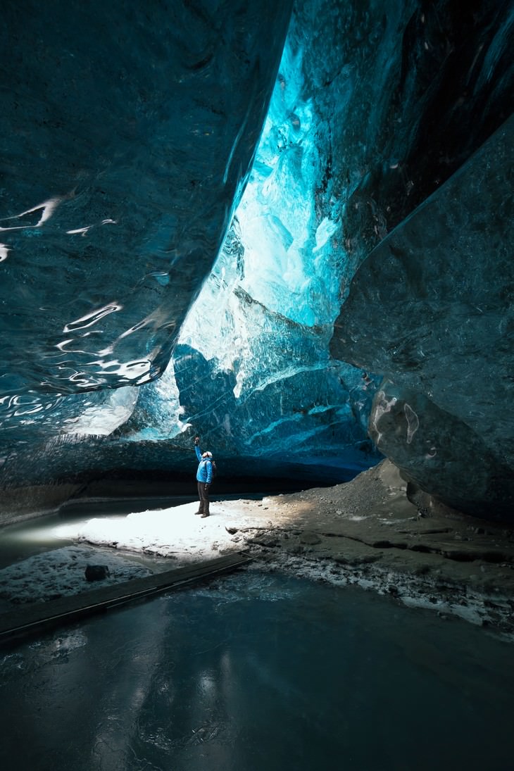 17. ¡La escala! Una persona de pie en una cueva de hielo en Islandia