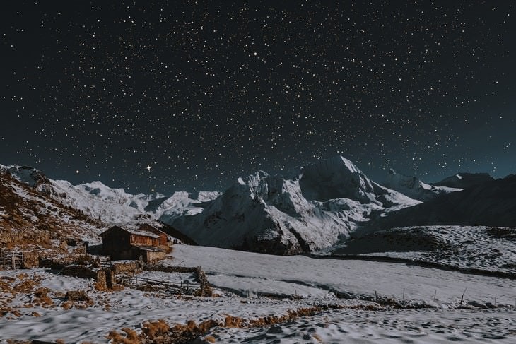 8. Estrellas brillando sobre un paisaje nocturno montañoso