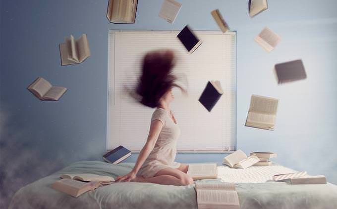 woman on bed throwing around books