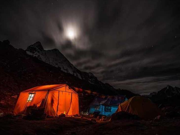 18 Fotos Acampando Bajo Las Estrellas Acampando en el Himalaya de Nepal, la luna se escondió detrás de nubes oscuras.
