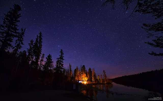 18 Fotos Acampando Bajo Las Estrellas . Un fuego distante arde en Thompson-Nicola, British Columbia, Canadá.