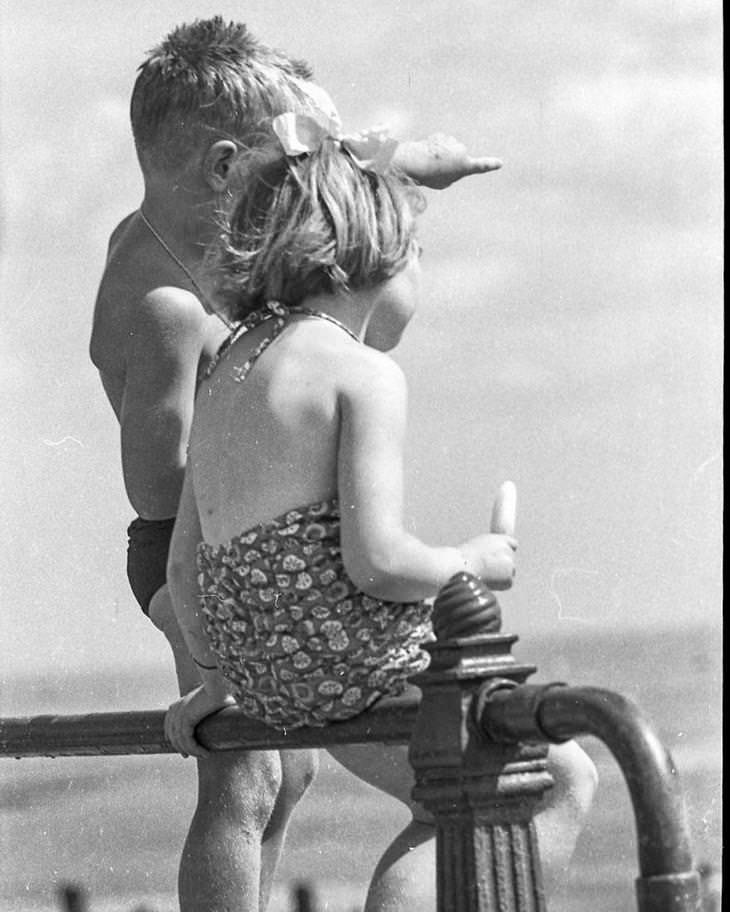 23 Fotografías Callejeras Del Siglo XX Que Te Dejarán Asombrado niños sentados en la playa
