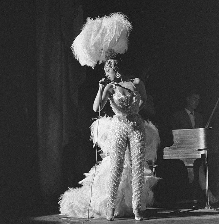 Josephine Baker: Siren of the Resistance, Josephine Baker in heavily feathered costume performing on stage in Amsterdam
