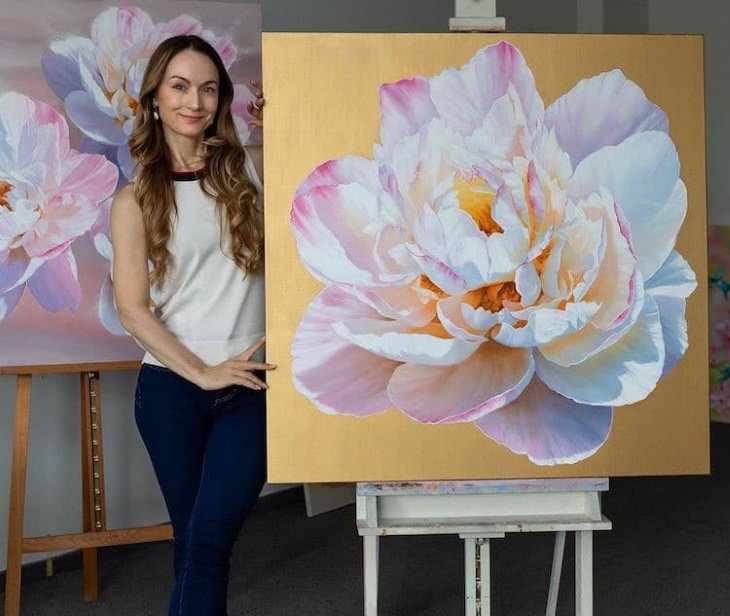 Pinturas Florales De Ira Volkova la artista posando con una pintura