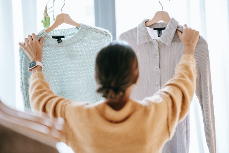 Consejos de limpieza rápida mujer sosteniendo el suéter y la camisa