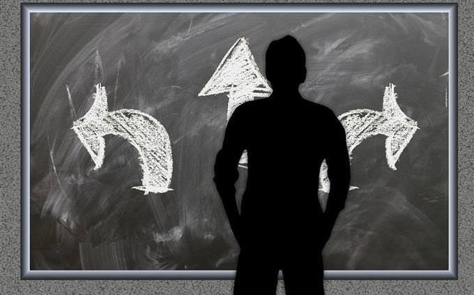 How your life flows: the silhouette of a man standing in front of a board with arrows