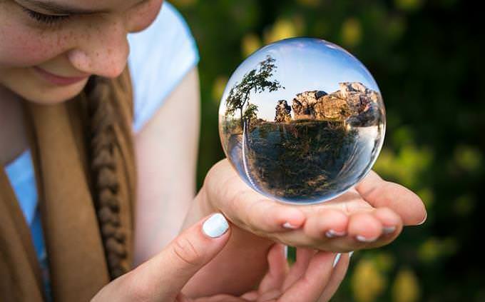 How your life flows: A girl looking at a landscape that appears inside a crystal ball