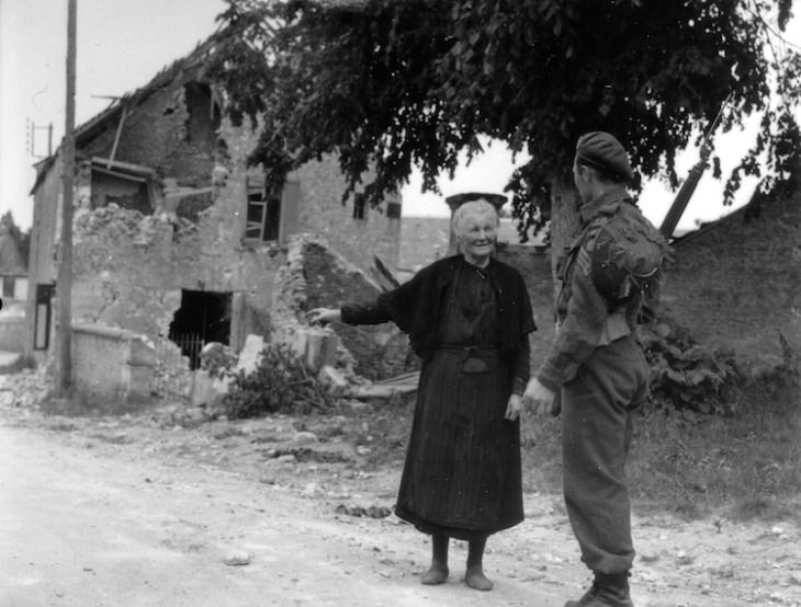 Fotos De Normandía De 1944 Un sargento y una lugareña mirando la destrucción.