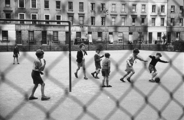 Niños Jugando En Las Calles De Londres Un partido de fútbol en curso