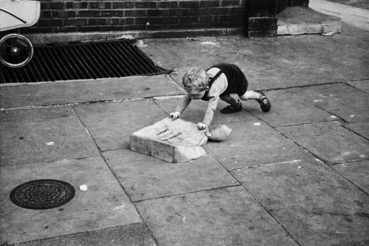 Niños Jugando En Las Calles De Londres Niño empujando una caja de cartón