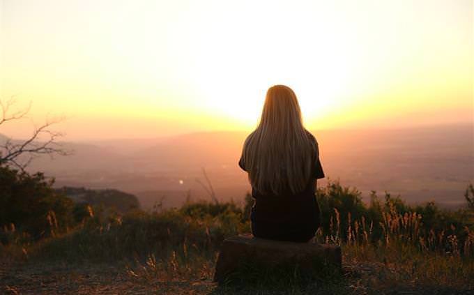 Woman sitting in nature in sunset