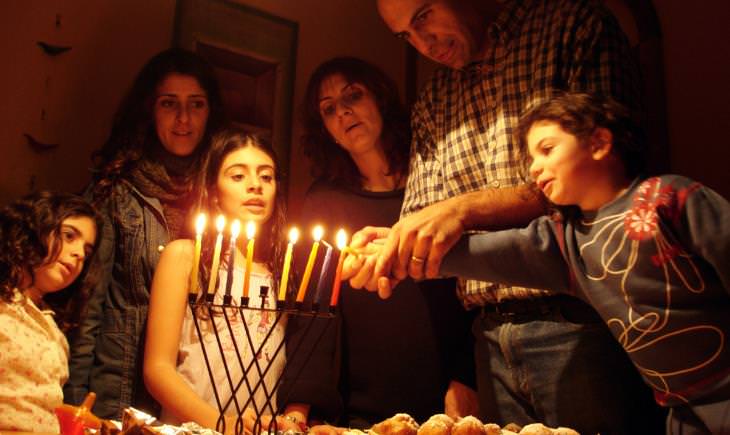 family lighting a menorah on Hanukkah