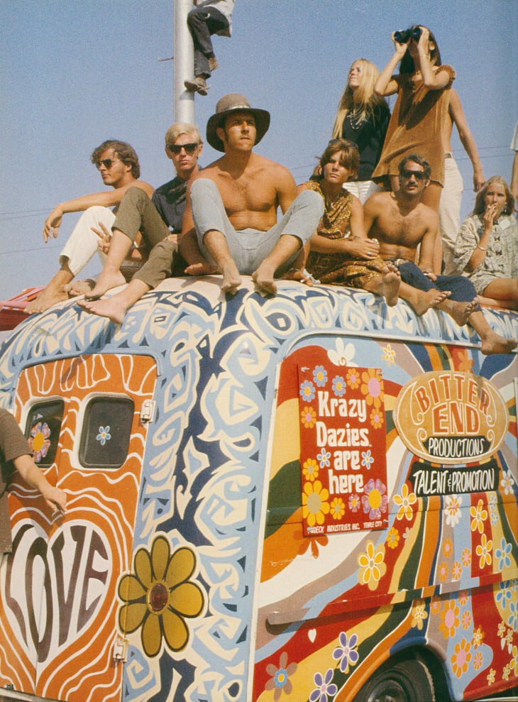 Gente de Woodstock sentada en una furgoneta de color 