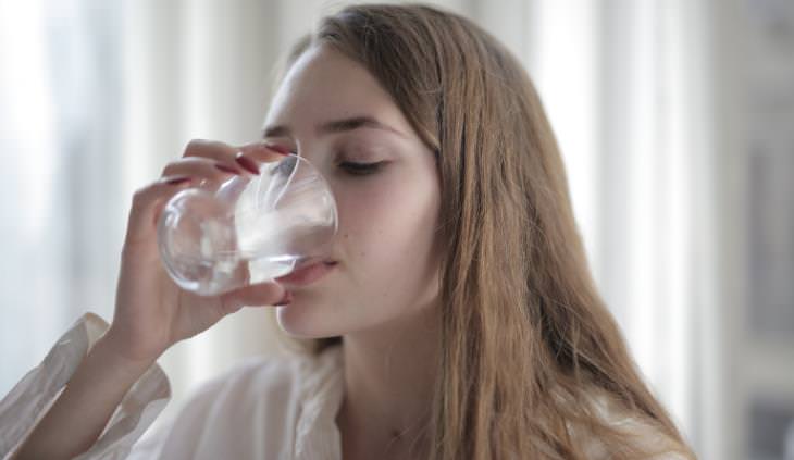 Deshidratación Después De La Vacuna De Refuerzo  Mujer bebiendo agua