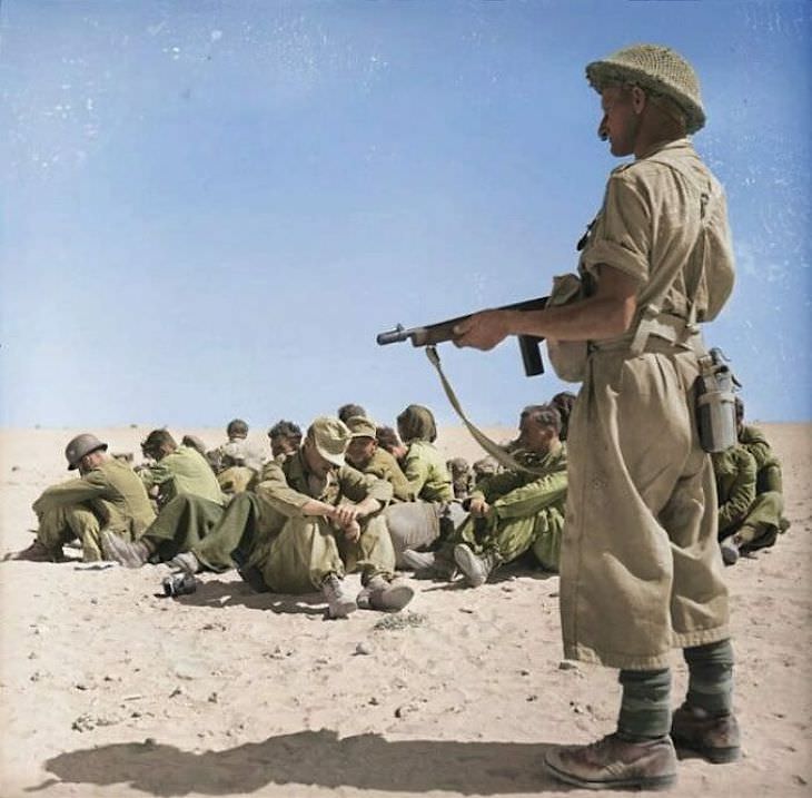 Fotos Extrañas a Color Un soldado de la División de Nueva Zelanda con vistas a un grupo de prisioneros de guerra alemanes durante la Segunda Batalla de El Alamein, noviembre de 1942