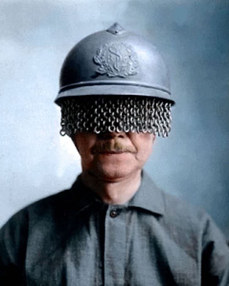 Fotos Extrañas a Color Soldado francés con un casco de acero de médico (según la insignia) cubierto con una pantalla de cadena incorporada para proteger los ojos de un soldado de rocas, proyectiles y otros fragmentos, 1918