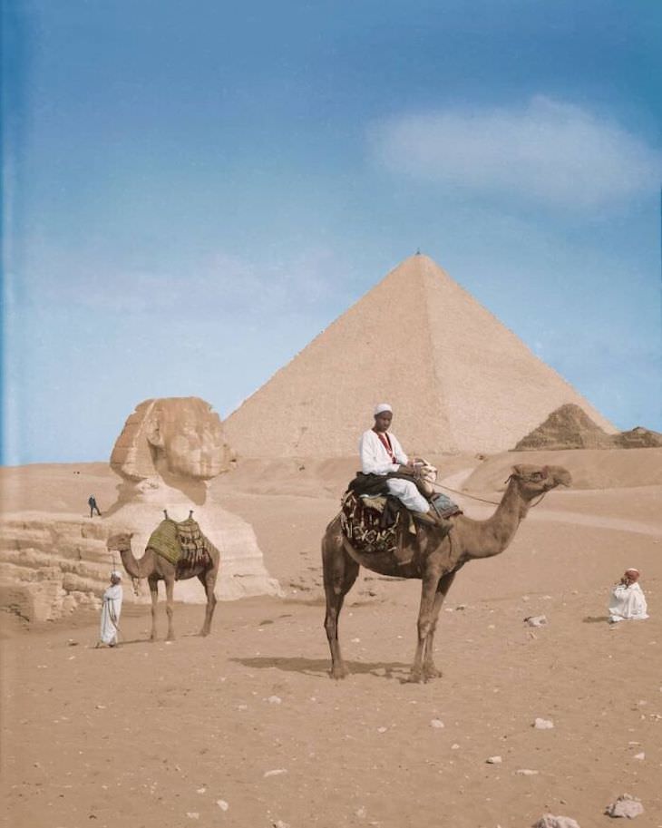 Fotos Extrañas a Color Dos lugareños se paran frente a un hombre que posa en la cima del Sphynx, Giza, c. 1900