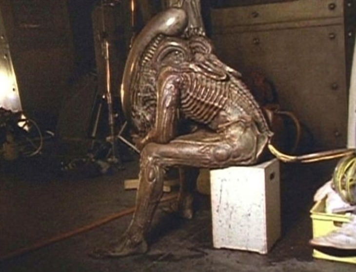 Fotos Detrás De Escenas De Películas Famosas  Bolaji Badejo, el actor que vistió el traje de Alien en la película “Alien” (1992), relajándose durante un descanso del rodaje.