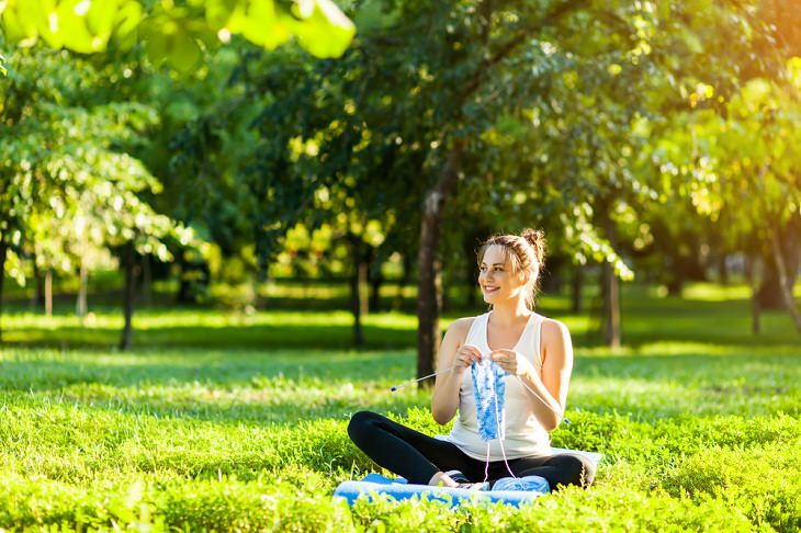  Los Grandes Beneficios Para La Salud De La Ecoterapia Mujer tejiendo en un parque