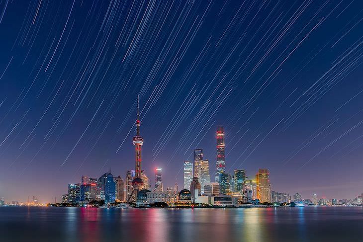  Finalistas Del Concurso De Fotografía De Astronomía Del Año Estelas de estrellas sobre el horizonte de la ciudad de Lujiazui, por Daning Kai en China