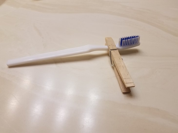 Trucos Para Organizar Tu Baño Usa una pinza para la ropa para mantener tu cepillo de dientes fuera de la encimera sucia