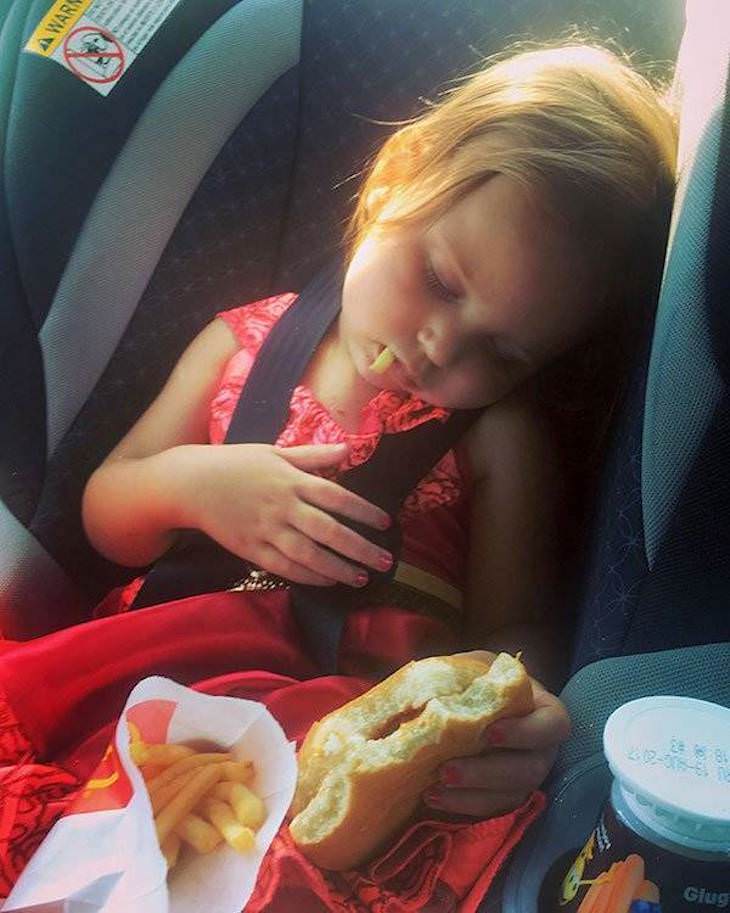 Fotos Divertidas La Vida Con Niños Niña durmiendo en el auto con una hamburguesa en la mano